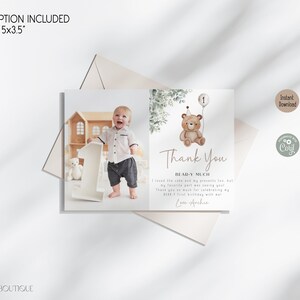 Peut inclure: Une carte de remerciement avec une illustration aquarelle d'un ours en peluche tenant un ballon. La carte comporte le texte "Thank You Bear-y Much" et une photo d'un b&eacute;b&eacute; gar&ccedil;on tenant un grand num&eacute;ro un. La carte mesure 5x3,5 pouces.