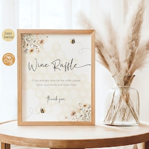 May include: A printable sign with a honeycomb pattern and floral accents. The sign says "Wine Raffle" and includes the text "If you brought wine for the raffle, please leave your bottle and ticket here! Thank you."