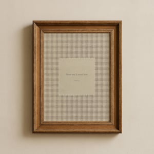 Puede incluir: Un marco de madera marrón con una impresión. La impresión presenta un fondo de patrón de cuadros vichy beige claro con un parche cuadrado en el centro. El parche tiene el texto "Here am I; send me."