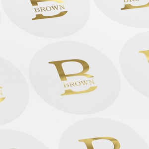May include: Gold foil stickers featuring the letter "B" with the word "BROWN" printed beneath. The stickers are displayed against a white backdrop.