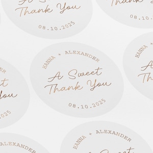 May include: Round white stickers with gold text. The text reads "Hanna + Alexander", "A Sweet Thank You", and "08.10.2025".