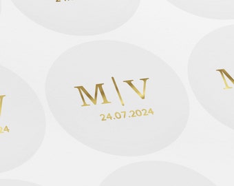 May include: White round stickers with gold lettering. The stickers feature the initials "M/V" and the date "24.07.2024".