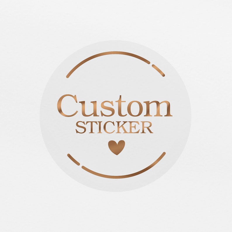 May include: A white circle sticker with a gold outline and the text "Custom Sticker" in gold lettering. A small gold heart is below the text.