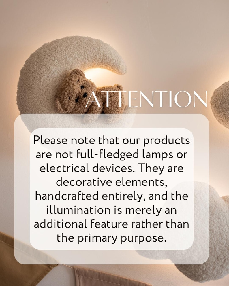 May include: A decorative wall lamp shaped like a crescent moon with a teddy bear. The lamp is made of a soft, textured material in cream and brown tones. The text "ATTENTION" is visible.