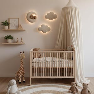 May include: A nursery scene with a light wood crib, a round rug, and plush toys. The wall features cloud and moon-shaped lights. A giraffe and a bunny plush sit near the crib. A canopy hangs over the crib.