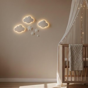 May include: A nursery scene featuring a wooden crib with a canopy and a beige blanket. The wall is adorned with illuminated cloud and star-shaped wall decor. A round woven rug sits on the wooden floor, with sunlight streaming in.