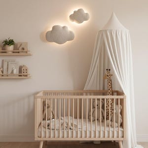 May include: A light wood cot with a mattress, surrounded by soft toys and a giraffe. Two cloud-shaped wall lights illuminate the room. A white canopy hangs above the cot, and a rug is on the floor. The room has a neutral colour palette.