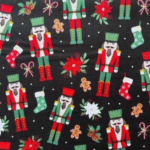 Tessuto natalizio con stelle di Natale e schiaccianoci