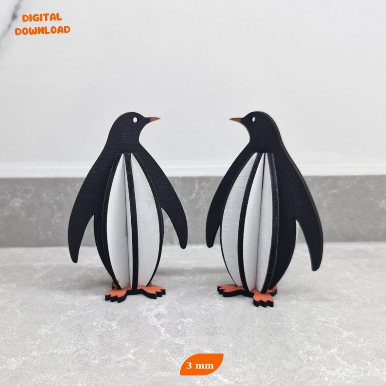 May include: Two black and white penguin figurines with orange feet. The penguins are 3 mm thick and are made of wood.
