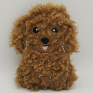 May include: A brown plush toy poodle with embroidered eyes, nose, and tongue. The toy is made of soft, fluffy material.