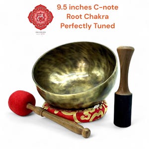 Könnte beinhalten: Eine bronzefarbene Klangschale, ca. 24 cm Durchmesser, mit Holzschlägel und rotem, goldenem Kissen. Der Text lautet "9.5 inches C-note Root Chakra Perfectly Tuned". Geeignet für Meditation und Klangtherapie.