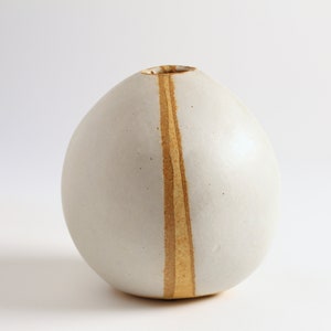 May include: A white ceramic vase with a single vertical stripe of brown glaze.