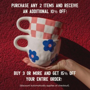 May include: Two ceramic mugs stacked on top of each other, held by a hand. The top mug has a pink and white checkered pattern, while the bottom mug is white with blue flower designs. Text on the image reads: "PURCHASE ANY 2 ITEMS AND RECEIVE AN ADDITIONAL 10% OFF!" and "BUY 3 OR MORE AND GET 15% OFF YOUR ENTIRE ORDER!"
