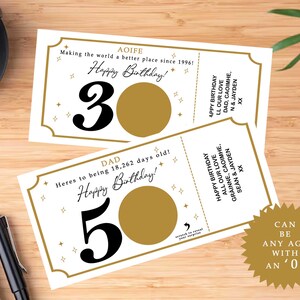 May include: Two birthday scratch-off cards with gold and white detailing. One card says "30" and the other says "50". The cards have the text "Happy Birthday!" and "Can be any age with an '0'".