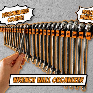 Op de afbeelding: Een wandorganizer voor moersleutels met een set sleutels. De organizer is oranje en bevat sleutels van verschillende maten. De afbeelding bevat de tekst "PERSONALIZED COLORS!", "SPACE SAVING!" en "WRENCH WALL ORGANIZER". Een hand houdt een van de sleutels vast.