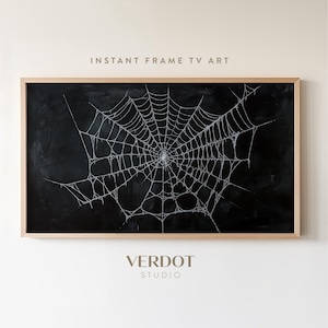 Puede incluir: Obra de arte enmarcada con fondo negro y diseño de telaraña blanca. El texto "INSTANT FRAME TV ART" está en la parte superior y "VERDOT STUDIO" en la inferior. El marco es de madera clara. Ideal para Halloween.