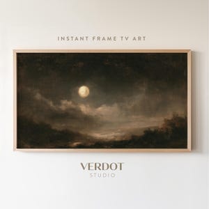 May include: A rectangular digital television art display in a light wood frame featuring a dark, moody landscape painting of a full moon glowing in a cloudy night sky above a shadowed horizon. The text INSTANT FRAME TV ART and VERDOT STUDIO appear.