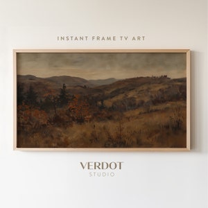 May include: A framed painting depicting a landscape with rolling hills, trees, and a distant town. The painting is in a light wood frame and features a muted colour palette of browns, greens, and greys.