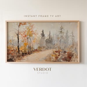 Può includere: Stampa artistica di paesaggio ad acquerello in una cornice di legno chiaro. L'opera raffigura un sentiero attraverso una foresta con alberi nei toni del giallo, arancione e marrone. Il testo "INSTANT FRAME TV ART" e "VERDOT STUDIO" sono visibili.