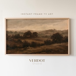 May include: A rectangular landscape painting in a light wood frame featuring a dark, moody scene of rolling hills, trees, and a cloudy sky. The text INSTANT FRAME TV ART appears above the frame, and VERDOT STUDIO is printed below.