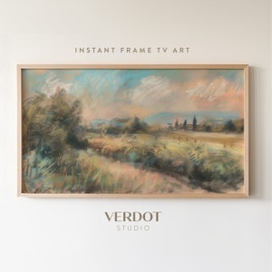 May include: A framed pastel painting of a landscape with a field of green grass, trees, and a distant mountain range. The sky is a soft blue with pink and orange clouds. The painting is in a light wood frame.