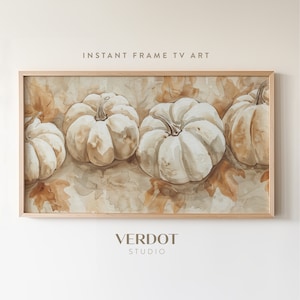 Puede incluir: Una pintura de acuarela enmarcada de cuatro calabazas blancas sobre un lecho de hojas marrones. La pintura tiene una sensación ligera y aireada, perfecta para agregar un toque de otoño a la decoración de tu hogar.