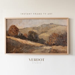 Puede incluir: Pintura de paisaje enmarcada con una paleta de colores cálidos. La obra representa colinas y árboles en tonos marrones, beige y naranja. El texto "INSTANT FRAME TV ART" y "VERDOT STUDIO" son visibles.