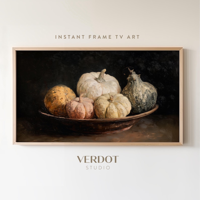 May include: A framed digital print featuring a still life of pumpkins in a dark, moody style. The pumpkins vary in color from white to orange and are arranged in a brown bowl. The text "INSTANT FRAME TV ART" is at the top.