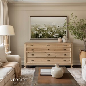 K&ouml;nnte beinhalten: Eine Kommode aus hellem Holz mit f&uuml;nf Schubladen und Messingbeschl&auml;gen. Die Kommode steht in einem Wohnzimmer mit einem Blumenbild dar&uuml;ber, einer Vase mit Blumen auf einem Couchtisch und einem Topf mit einem Olivenbaum.