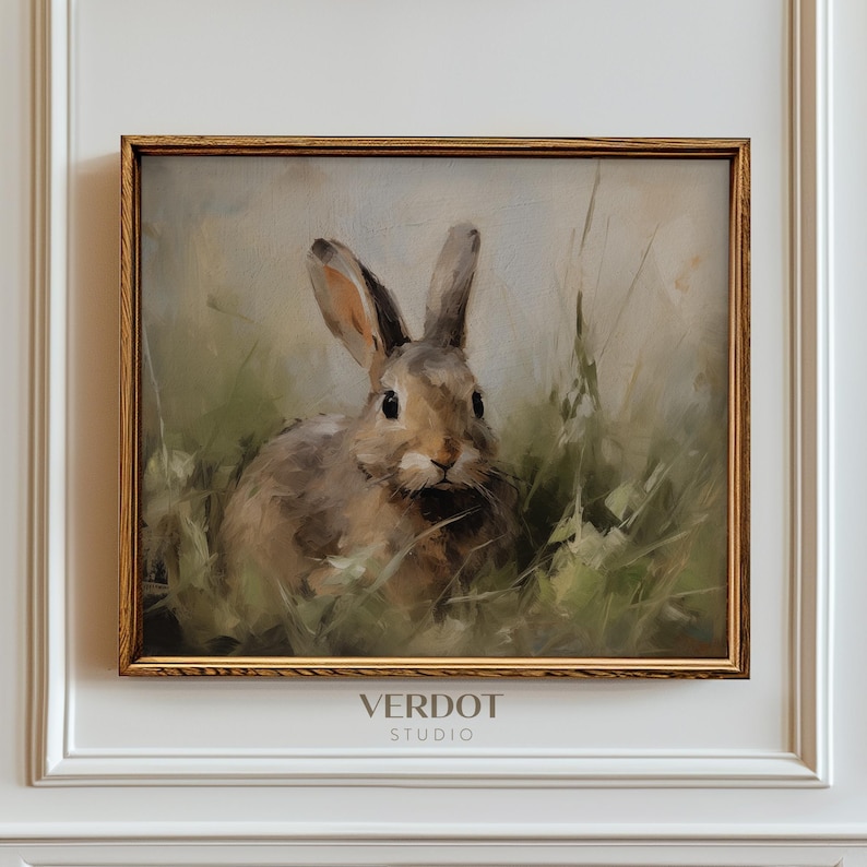 May include: A framed painting of a brown rabbit sitting in a field of green grass. The rabbit is looking directly at the viewer. The painting is in a gold frame.