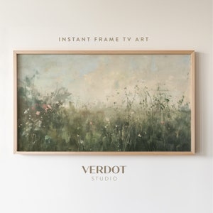 May include: A framed painting of a field of green grass and wildflowers with a hazy sky in the background. The frame is a light wood color. The text "INSTANT FRAME TV ART" is at the top of the image and the text "VERDOT STUDIO" is at the bottom of the image.