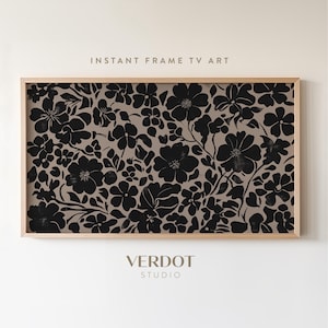 May include: A framed print with a black and white floral pattern on a beige background. The print has a distressed look and is framed in a natural wood frame. The text "INSTANT FRAME TV ART" is at the top of the frame and the text "VERDOT STUDIO" is at the bottom of the frame.