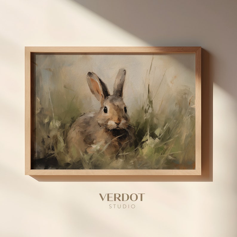 May include: A painting of a brown rabbit sitting in a field of green grass. The rabbit is looking directly at the viewer. The painting is framed in a light brown wood frame.