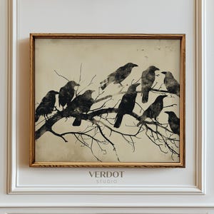 Op de afbeelding: Een zwart-witte illustratie van een zwerm kraaien die op kale takken zitten. De afbeelding heeft een vintage, antieke uitstraling en is ingelijst in een gouden lijst. De tekst "VERDOT STUDIO" is onder de afbeelding gedrukt.