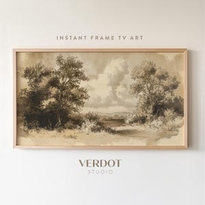 May include: A framed sepia-toned landscape painting depicting a forest scene with two trees in the foreground and a river in the distance. The painting has a vintage aesthetic and is framed in a light wood frame.