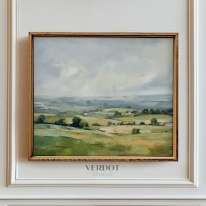 May include: A framed landscape painting with a view of a rolling green field with trees and a cloudy sky. The painting is in a gold frame and has the text "VERDOT STUDIO" at the bottom.