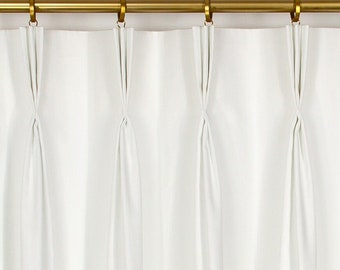 May include: White curtains with triple pleats hanging from a gold curtain rod.