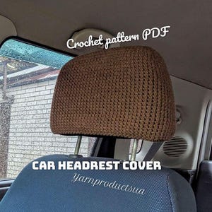 Könnte beinhalten: Ein brauner, gehäkelter Auto-Kopfstützenbezug, der über einer Kopfstütze angebracht ist. Das Bild enthält den Text "Crochet pattern PDF" und "CAR HEADREST COVER" sowie den kursiven Schriftzug "Yarnproductsua" auf dem Autositz.