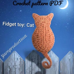 May include: A crocheted orange cat-shaped fidget toy with a curled tail. The image includes the text Crochet pattern PDF, Fidget toy: Cat, and Yarnproductsua. The cat is rendered in a textured yarn stitch against a blue night sky background.