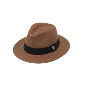 Może przedstawiać: Brązowy kapelusz typu fedora z czarną opaską i ozdobnym guzikiem. Kapelusz ma szerokie rondo i strukturalną koronę. Kapelusz jest wykonany z tkanego materiału.