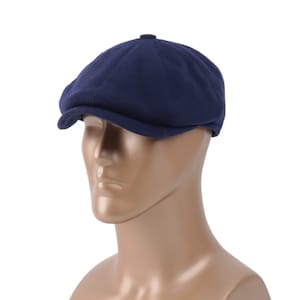 May include: A navy blue newsboy cap with a rounded crown and a short brim.