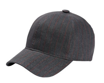 May include: A gray baseball cap with red vertical stripes. The cap has a curved brim and a small button on top. The fabric has a subtle texture, and the stitching is visible along the seams.