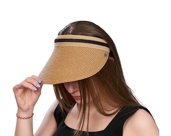 May include: A woven straw visor with a black and tan striped band. The visor is a light tan color and has a curved brim. A small silver-colored emblem is on the side of the visor.