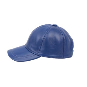 Può includere: Cappellino da baseball in pelle blu con visiera curva. Il cappello presenta un design a sei pannelli con cuciture a vista e un piccolo bottone sulla parte superiore. Il colore è blu acceso.