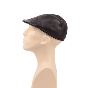 Puede incluir: Una gorra plana de cuero marrón con un detalle de costura.