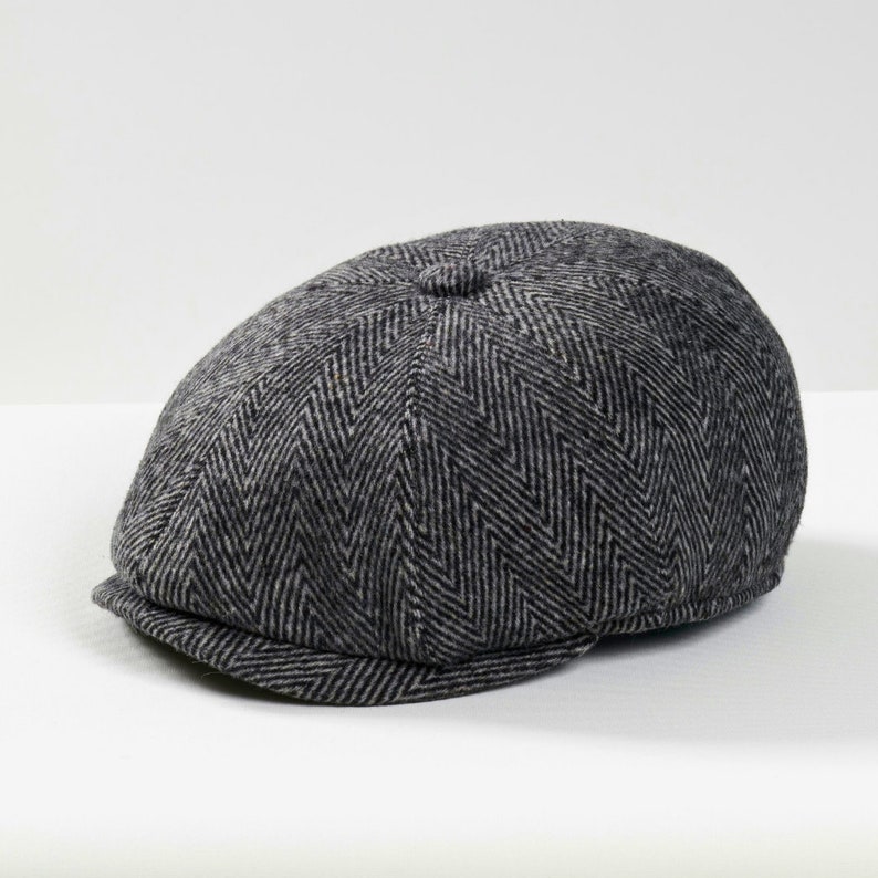 May include: A gray herringbone patterned newsboy cap.
