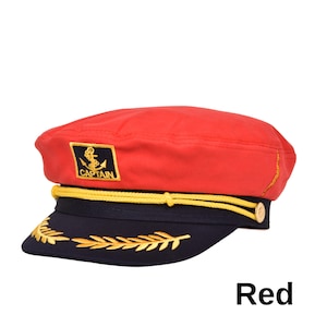 May include: Red captain's hat with a navy blue brim and gold embroidered details. The hat features a gold rope trim and a gold anchor emblem with the word "CAPTAIN". The word "Red" is printed at the bottom.