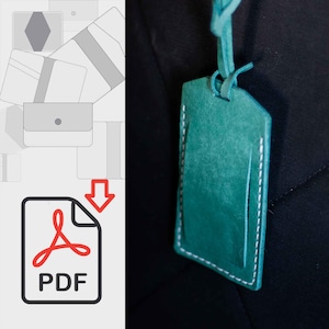 Puede incluir: Un llavero de cuero color turquesa con costuras blancas. El llavero está colgado de una superficie negra.