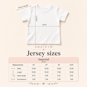 Puede incluir: Una camiseta blanca con medidas de ancho, largo y largo de manga. La imagen incluye una tabla de tallas con medidas en pulgadas para las tallas 2T, 3T, 4T y 5-6T. Tambi&eacute;n se ve el texto "AMAICYM" y "Jersey sizes".