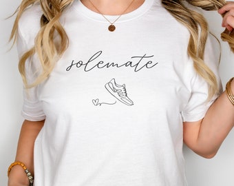 May include: White t-shirt with the text "solemate" and a running shoe graphic.